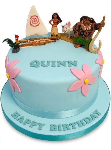 Light blue Moana themed birthday cake with Moana, Maui, Pua, Heihei figurines, boat, and pink flowers.