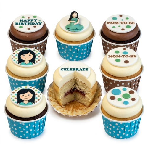 Cupcakes with pregnant woman topper, "MOM-TO-BE", "HAPPY BIRTHDAY", and girl face toppers in blue and brown wrappers.