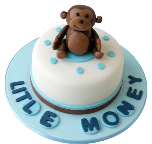 Round white cake with a 3D brown monkey topper, blue polka dots, and "LITTLE MONKEY" text.