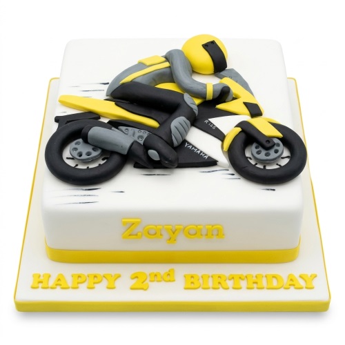 White square birthday cake with 3D yellow and black racing motorbike and rider figure.