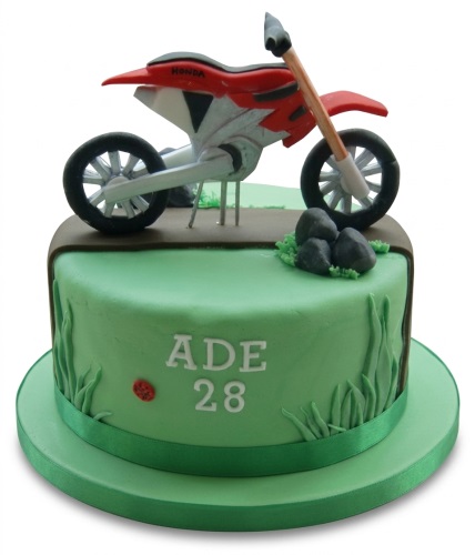 Green motocross birthday cake with a red dirt bike topper and custom age.