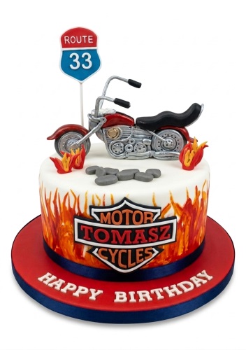 Round white cake with red motorcycle, 'Route 33' sign, flames, and 'Happy Birthday' message.