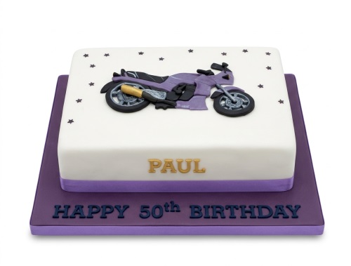 White square cake with purple motorcycle decoration and star sprinkles, on a purple cake board.