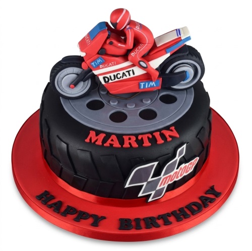 Black tyre-themed birthday cake with a red Ducati motorcycle and rider topper, and MotoGP logo.