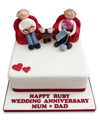 White rectangular anniversary cake with fondant figures of a couple, red hearts, and custom message.