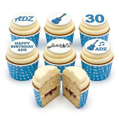 Cupcakes with blue guitar and musical note toppers, white frosting, and blue polka dot cases.