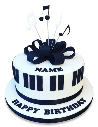 White round birthday cake with black piano keys, a black bow, and musical note toppers, with space for a personalised name.