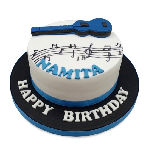 Round white birthday cake with a blue guitar topper, musical notes, and a personalised name.