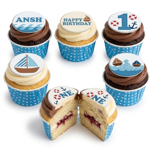 Nautical theme cupcakes with sailboats, waves, anchors, and lifebuoys on blue polka dot wrappers.