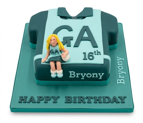 Netball shirt shaped birthday cake with a fondant netball player figurine and custom age topper.