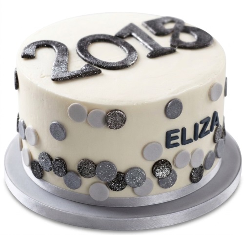 White birthday cake with glittery numbers and grey polka dots, personalised with a name.