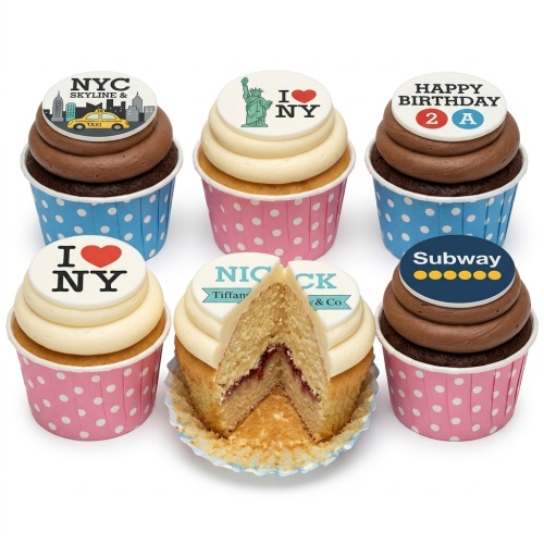 Set of six New York City themed cupcakes with various edible toppers including skyline, Statue of Liberty, I Love NY, and Subway logo.