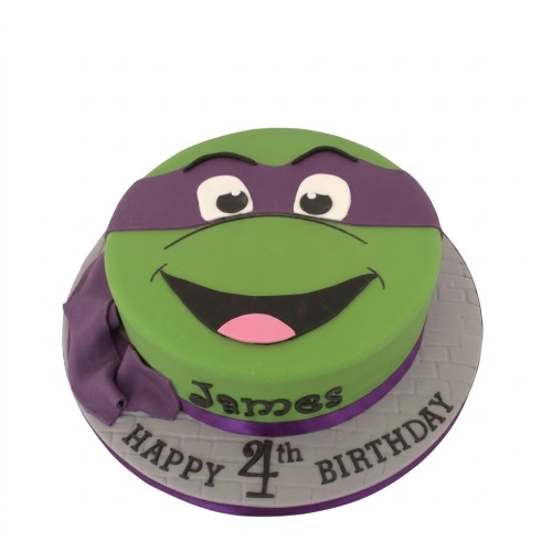 Round green Teenage Mutant Ninja Turtle Donatello cake with purple mask, personalised name and custom age.