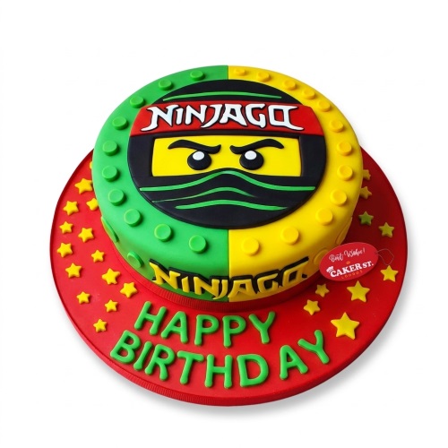 Round two-tier Ninjago themed birthday cake with green and yellow halves, Ninjago character face, logo, and yellow stars on a red board with 'Happy Birthday' message.