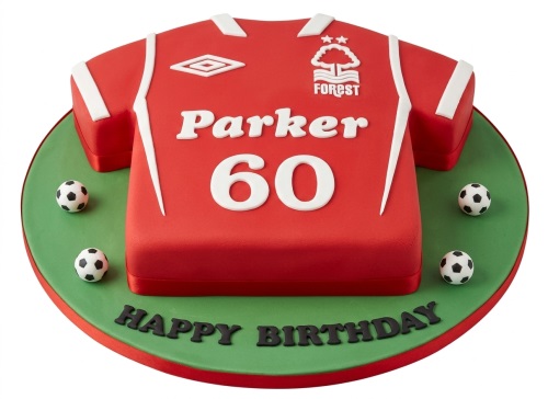 Red Nottingham Forest football shirt shaped birthday cake with white trim, club logo, and small footballs on a green board.