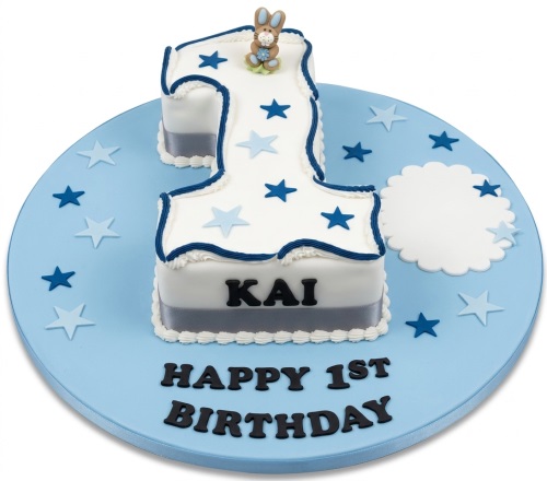 White number 1 cake with blue stars, a bunny topper, and a personalised name for a 1st birthday.