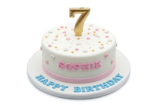 Round white birthday cake with pink and white flowers, gold sprinkles, a gold number topper, and a personalised name.