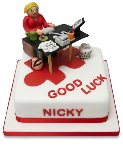 White square cake with edible female figurine at an office desk, with a red 'Good Luck' message.