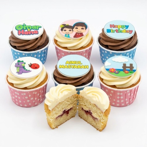 Assortment of Omar & Hana themed cupcakes with character, dinosaur, ladybug, and landscape toppers.