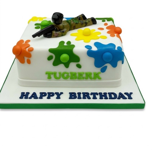 White square birthday cake with a camouflage paintball figure and colourful paint splatters.