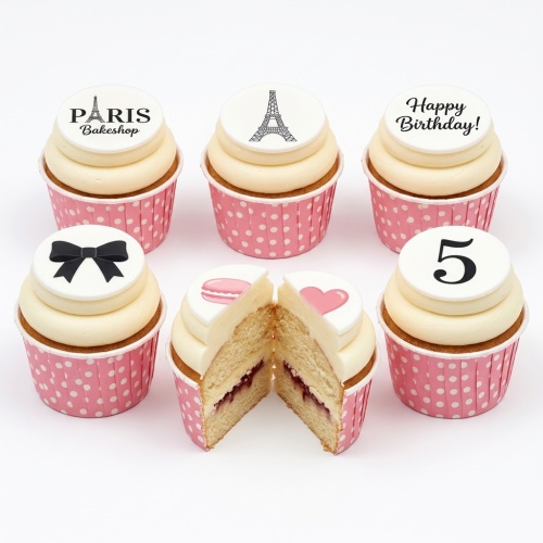 Elegant Paris theme birthday cupcakes with Eiffel Tower, bow, macaron, heart, and custom age topper.