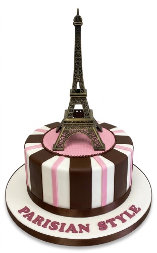 Round Parisian style birthday cake with Eiffel Tower topper, pink and brown stripes, and "PARISIAN STYLE" text.