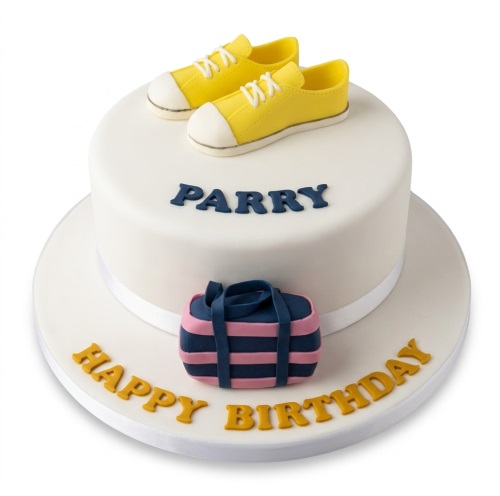 White birthday cake with yellow trainers, a pink and blue duffel bag, and a personalised name.