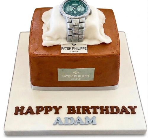 Edible Patek Philippe watch on a brown watch box birthday cake with "Happy Birthday" message.