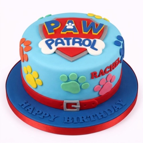 Round blue Paw Patrol themed birthday cake with logo, colourful paw prints, and a red collar design.