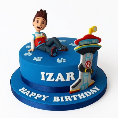 Round blue Paw Patrol birthday cake with Ryder figurine and Lookout Tower, decorated with paw prints and a personalised message.