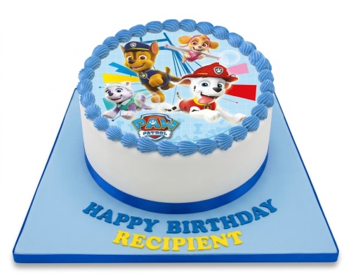 Round white Paw Patrol birthday cake with blue piping and custom message on a blue board.