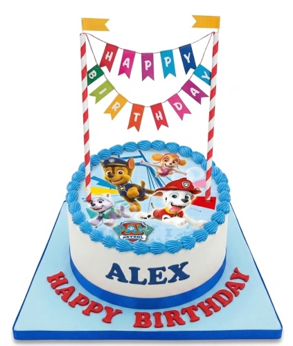 Round white Paw Patrol birthday cake with Chase, Skye, Marshall, Everest, blue trim, and a 'Happy Birthday' banner.