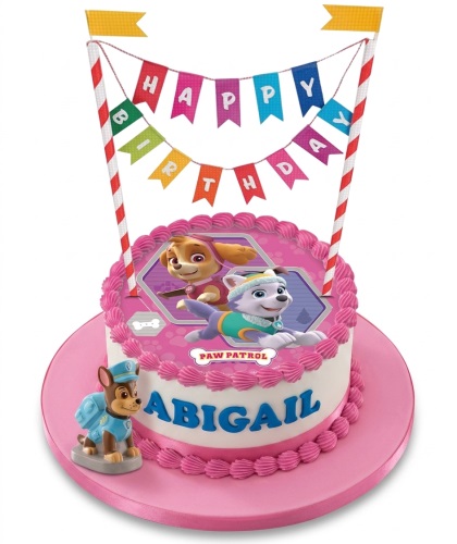Round pink and white Paw Patrol birthday cake with Skye, Everest, and Chase figures, "Happy Birthday" banner, and personalised name.