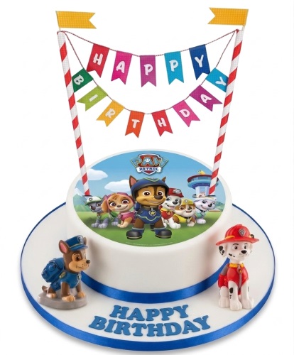 Round white Paw Patrol birthday cake with edible image, Chase and Marshall figurines, and 'Happy Birthday' bunting.