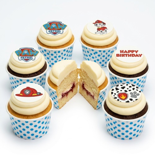 Paw Patrol themed birthday cupcakes with Marshall and fire helmet toppers, in blue polka dot cases.