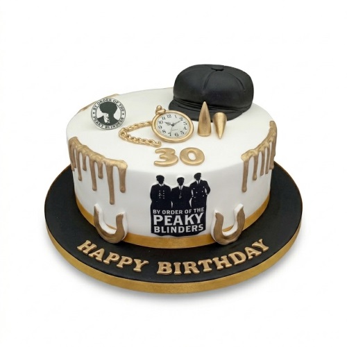Round white Peaky Blinders theme birthday cake with black flat cap, gold pocket watch, and custom age topper.
