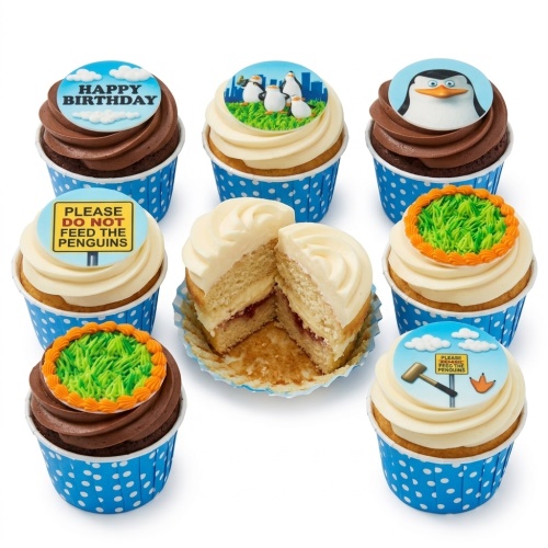 Set of Madagascar Penguin themed birthday cupcakes with chocolate and vanilla frosting, blue polka dot cases, and edible toppers.