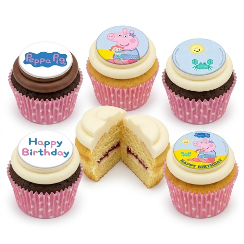 Selection of Peppa Pig themed birthday cupcakes with white and brown frosting, pink polka dot wrappers, and edible Peppa Pig, sun and crab, and Happy Birthday toppers.