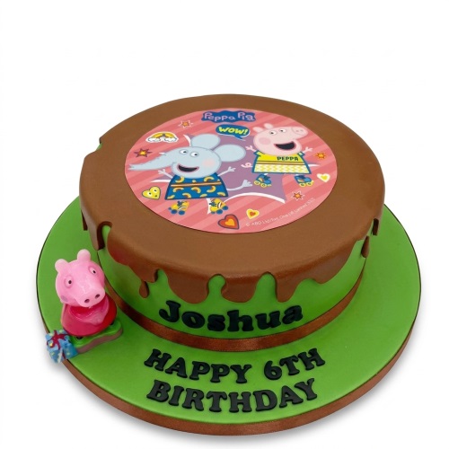 Round Peppa Pig themed birthday cake with a green base, brown chocolate drip, and an edible image of Peppa Pig characters on top, with a small Peppa Pig figurine on the side.