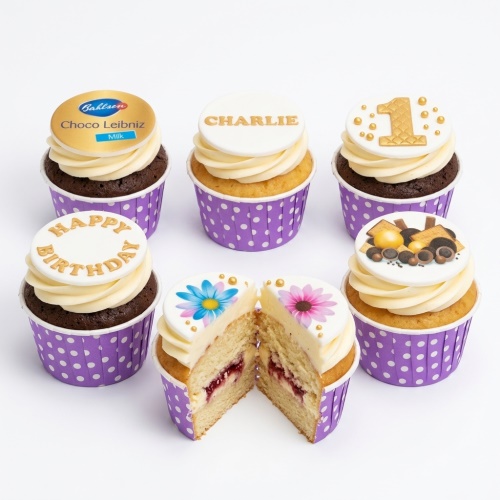 Assortment of personalised birthday cupcakes with custom age, name, message, floral, and sweet-themed toppers in purple wrappers.