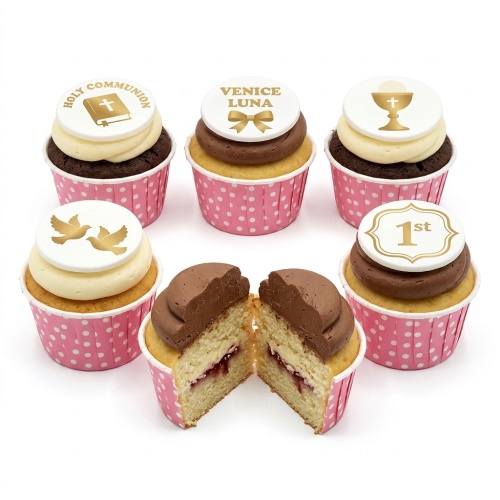 Cupcakes with gold Holy Communion, chalice, doves, and '1st' toppers on white fondant discs, in pink polka dot wrappers.