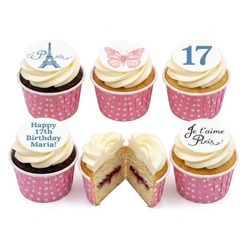 Paris themed birthday cupcakes with Eiffel Tower, butterfly, and custom age toppers on pink polka dot wrappers.