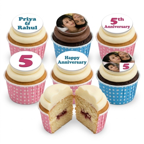 Anniversary cupcakes with custom photo, name, and number toppers in pink and blue cases.