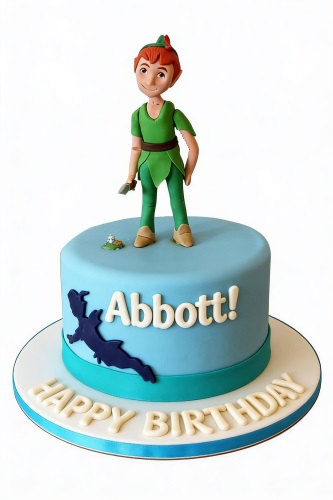 Single-tier light blue Peter Pan birthday cake with a character topper and personalised name.