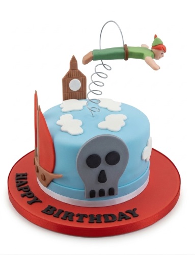 Round blue Peter Pan themed birthday cake with a flying Peter Pan figure, Big Ben, clouds, pirate skull, and red board.
