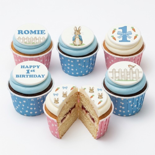 Peter Rabbit 1st Birthday cupcakes with blue and pink wrappers, featuring Peter Rabbit, number one, and personalised name toppers.
