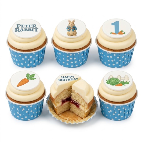 Peter Rabbit themed cupcakes with white icing, blue polka dot wrappers, and edible toppers featuring Peter Rabbit, carrots, a cabbage, a fence, and the Peter Rabbit logo.