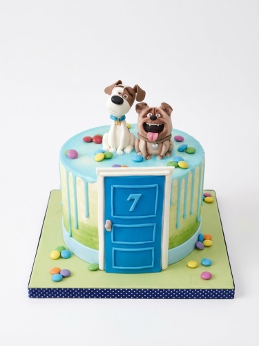 Secret Life of Pets themed birthday cake with Max and Duke figures, blue door, and custom age '7'.