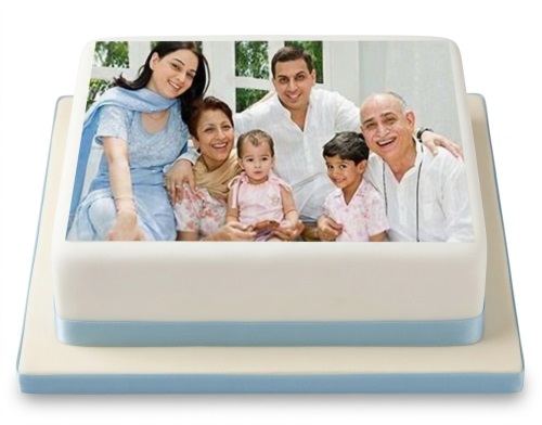 Square white Personalised Photo Cake with a family photo printed on top, decorated with a blue ribbon.