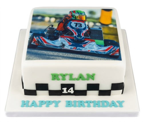 White square go-kart racing birthday cake with edible photo of a racer and checkered flag border.